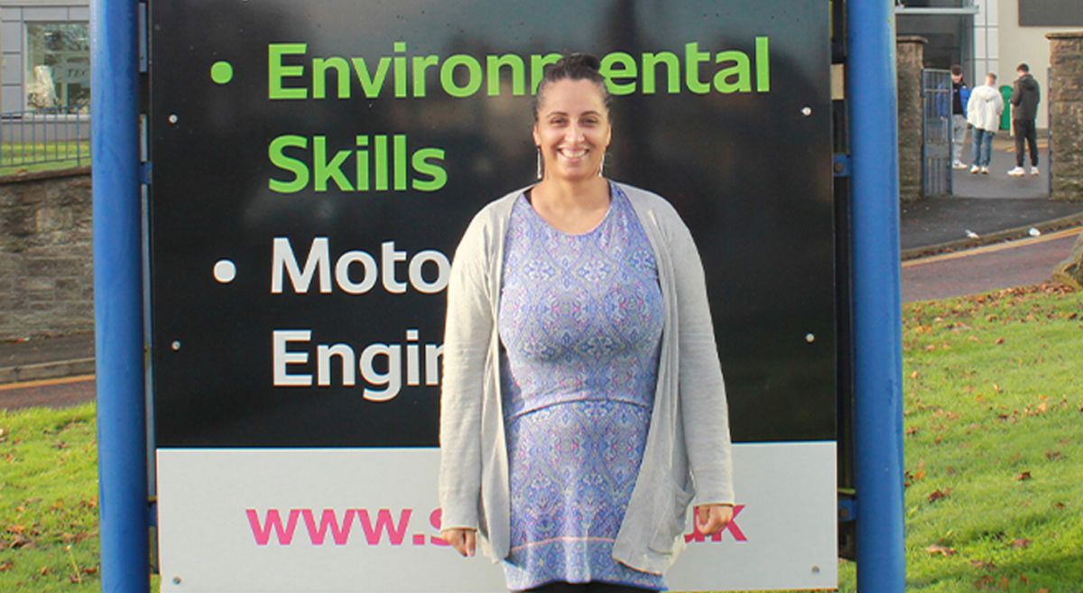 Gnanam Samuel pictured in front of a sign reading 'Environmental Skills' and 'Motorsport Engineering'